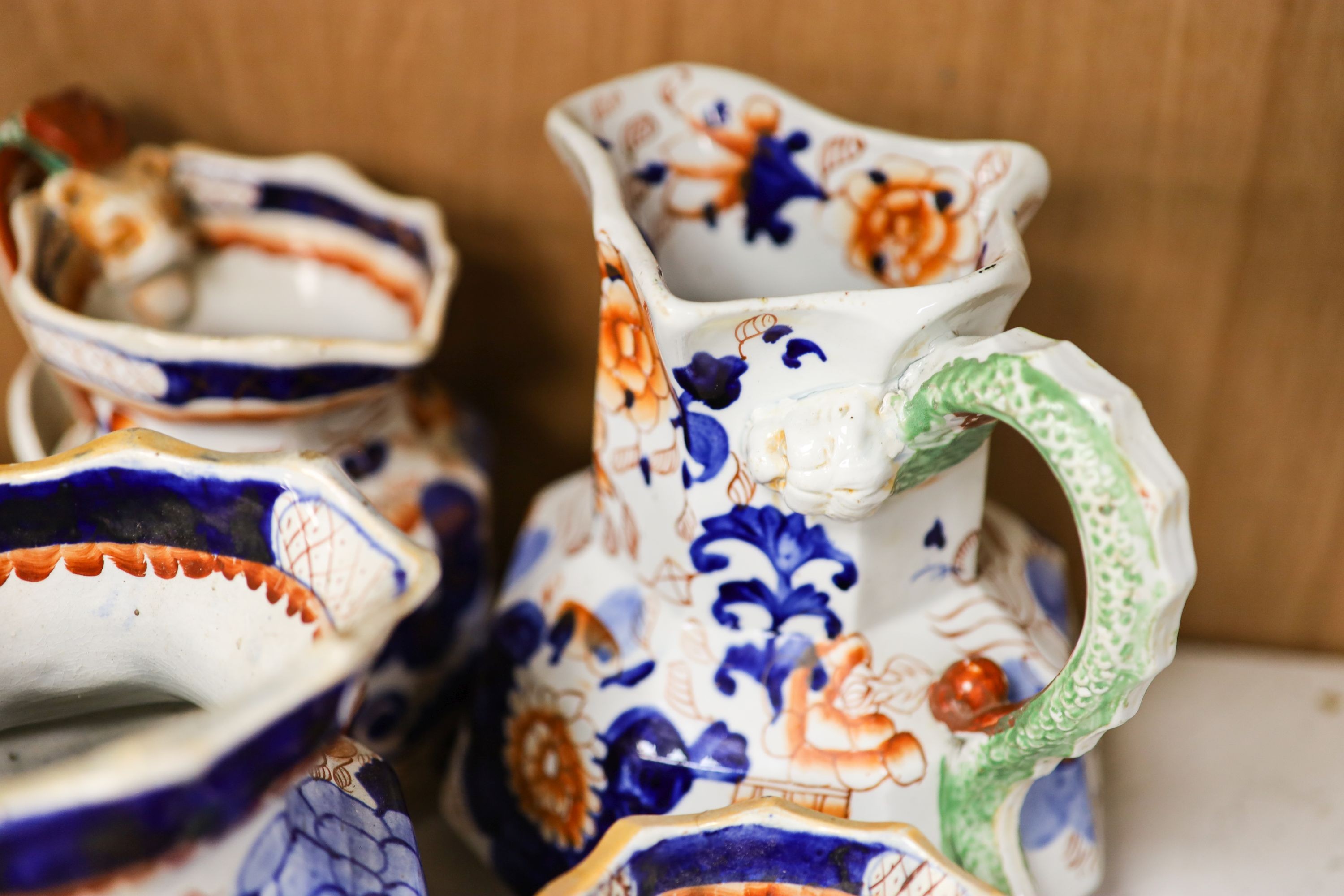 Nine pieces of Victorian Masons Ironstone, five Hydra jugs, a Delft charger and relief moulded teapot.